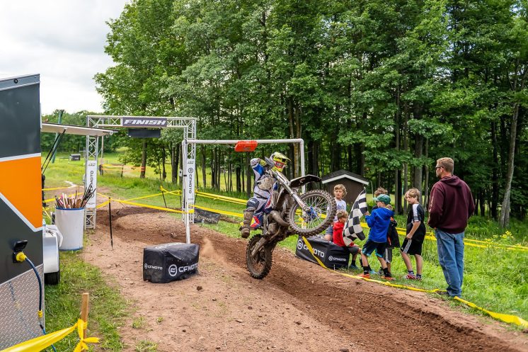 Bret Holland pops a wheelie while finishing a dirt bike race